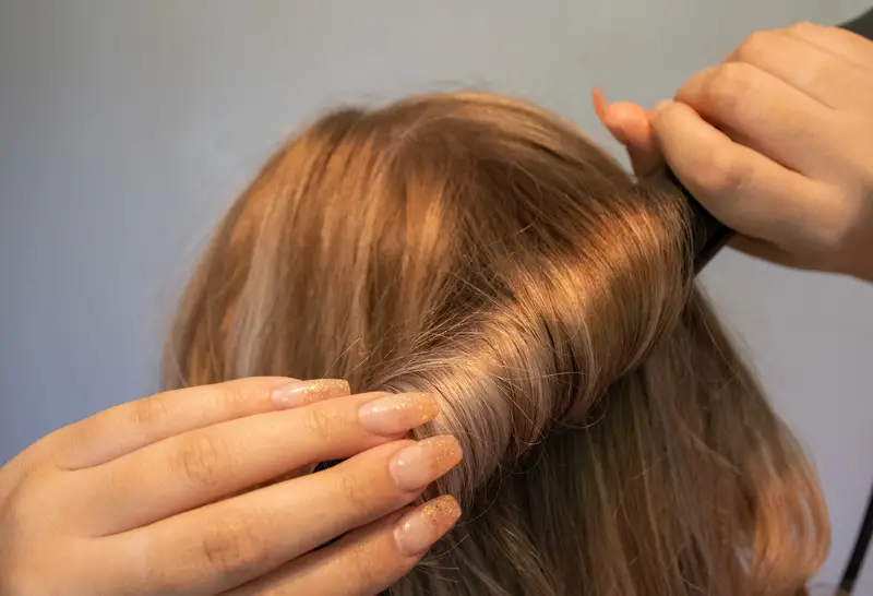 Woman curling her hair with a curling iron