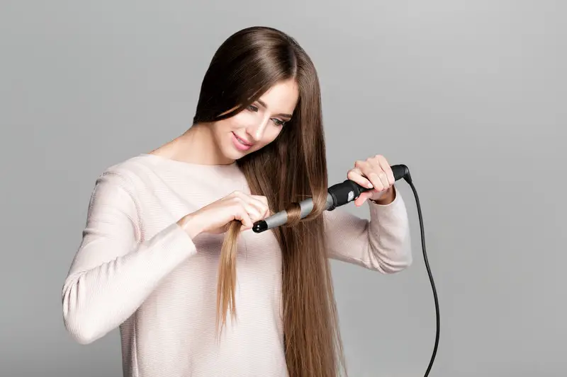 woman using curling iron